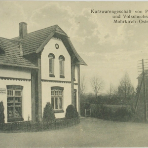 1907/08 erbaut<br />
Pauline Hansen aus Böel zieht am 01.01.1907 nach Mohrkirch und baut das Haus. Sie richtet einen kleinen Laden mit Schreibwaren jeglicher Art, mit den Gebrauchsgegenständen für alle Handarbeiten. Der Laden war ausgerichtet nach den Bedürfnissen der Volkshochschule, die im gleichen Jahr gebaut wurde. Quelle: Chronik Mohrkirch, S. 393